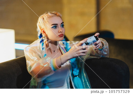 Portrait of a young female gamer playing console. Portrait of a young female gamer playing console. 105757329