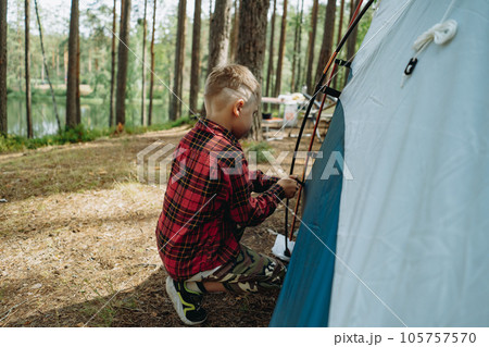 cute little caucasian boy putting up a tent. Family camping concept 105757570