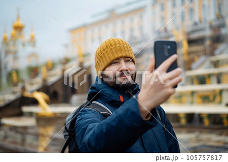caucasian man, tourist in Saint petersburg taking photo in front of fountain in Peterhof park caucasian man, tourist in Saint petersburg taking photo in front of fountain in Peterhof park 105757817