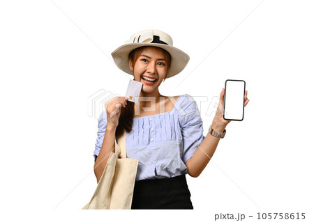 Excited woman tourist holding credit card and showing smartphone with blank screen. Holiday, vacation, traveling concept 105758615