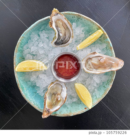 Gourmet food. Delicious oysters with ice and lemon, top view 105759226