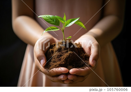 Child holds a small blooming plant in hand. Child holds a small blooming plant in hand. 105760006