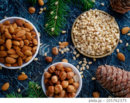 Assorted shelled nuts in bowls. Hazelnuts, almonds and pine nuts. Still life from placer of nuts Assorted shelled nuts in bowls. Hazelnuts, almonds and pine nuts. Still life from placer of nuts 105762375