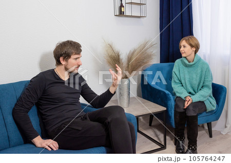 A man sitting on the couch, in consultation with a psychologist in the office A man sitting on the couch, in consultation with a psychologist in the office 105764247