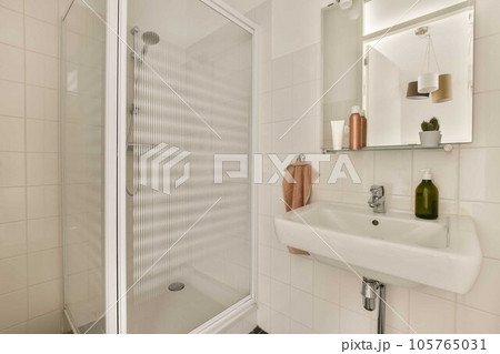 a bathroom with a sink, mirror and towel rack on the wall next to it is a glass shower door a bathroom with a sink, mirror and towel rack on the wall next to it is a glass shower door 105765031