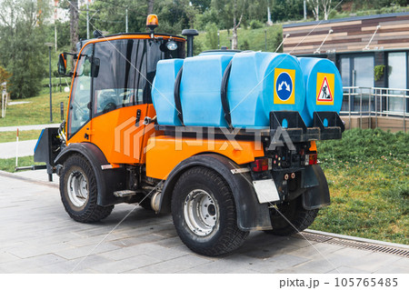 small tank truck for cleaning paths and watering plants in the city park small tank truck for cleaning paths and watering plants in the city park 105765485