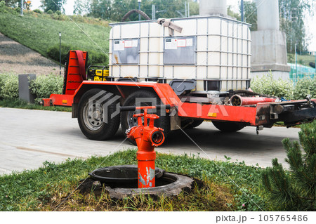 fire hydrant on the background of a trailer in water tanks for watering plants 105765486