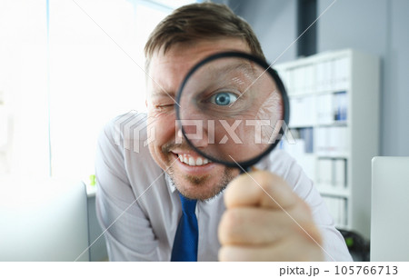 Smiling businessman hold magnifying glass 105766713