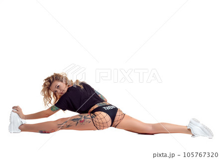 Sexy blond twerk woman with tattoed body and long curly hair is posing in studio. 105767320