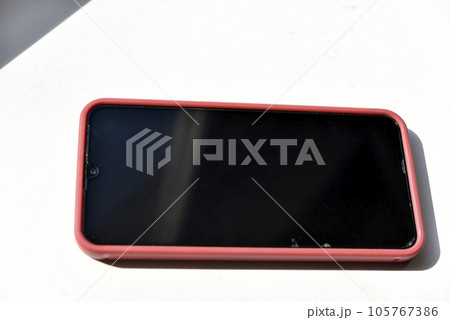 A smartphone in a red case and a black screen. Red phone on a white background. 105767386