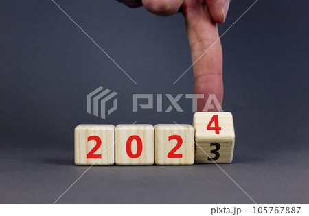 2024 happy new year symbol. Wooden cubes with number 2023 and 2024. Beautiful grey table grey background, copy space. Businessman hand. Business and 2024 happy new year concept. 105767887