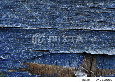 The surface of old rotten boards. Cracks in the wood. Old plywood. Traces of paint. The surface of old rotten boards. Cracks in the wood. Old plywood. Traces of paint. 105768065