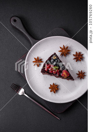 Delicious sweet chocolate brownie cake with blueberries, currants and raspberries 105769260