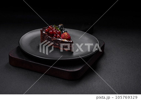 Delicious sweet chocolate brownie cake with blueberries, currants and raspberries Delicious sweet chocolate brownie cake with blueberries, currants and raspberries 105769329