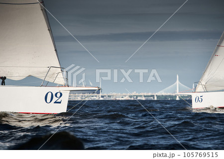 Bowsprit of sailing yachts are in sailing regatta at sunset, the clear sky, hot racing, bridge Bowsprit of sailing yachts are in sailing regatta at sunset, the clear sky, hot racing, bridge 105769515