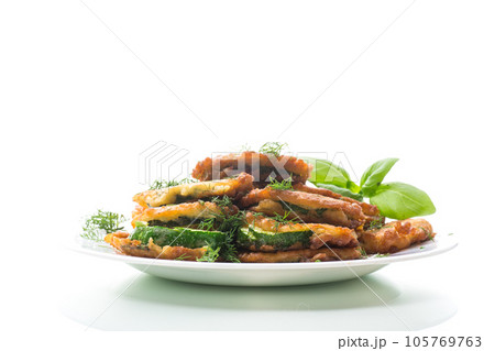 zucchini fried in circles in batter with herbs, in a plate. zucchini fried in circles in batter with herbs, in a plate. 105769763