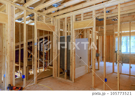 Bathroom remodel under plumbing work connecting installation of pipes with installed new acrylic bathtub for new house 105773521