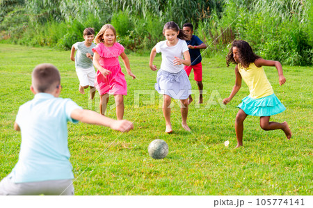Group of kids playing football on grass 105774141