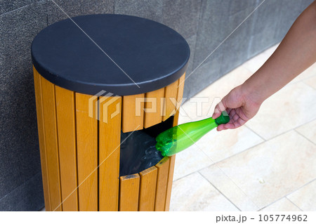 Hand throwing empty plastic bottle into recycle garbage trash. 105774962