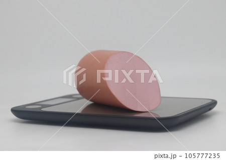 pork sausage on electronic kitchen scale isolated on white background. Sausage on a cutting board pork sausage on electronic kitchen scale isolated on white background. Sausage on a cutting board 105777235