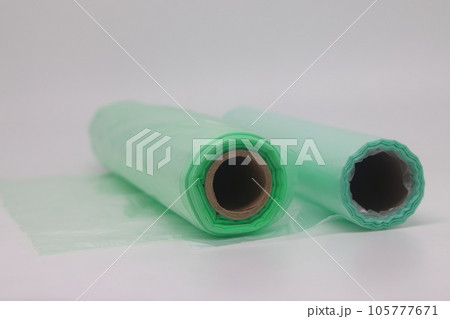 Green food grade plastic plastic bag isolated on white background. Roll of green plastic trash bags 105777671
