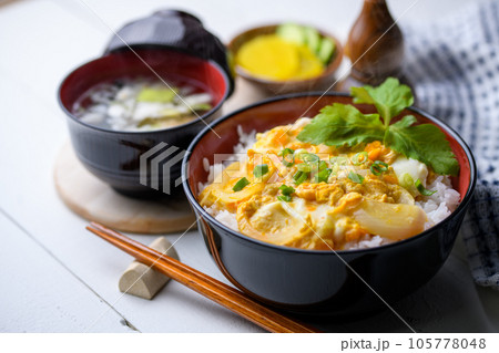 和食の定番！ふわふわの卵丼（たまご丼）お味噌汁と三つ葉を添えて 半熟卵（白板背景） 105778048