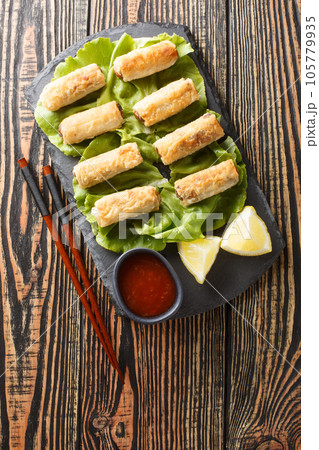 Cha Gio Vietnamese Fried Spring Rolls stuffed with chicken closeup on the plate. Vertical top view 105779935