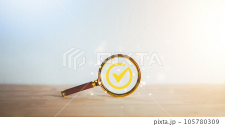 Magnifying glass with correct check marks on wooden table.Top service and correct. ISO certification, Guarantee, Quality assurance, Standard, Standardization. Customer service evaluation, satisfaction Magnifying glass with correct check marks on wooden table.Top service and correct. ISO certification, Guarantee, Quality assurance, Standard, Standardization. Customer service evaluation, satisfaction 105780309