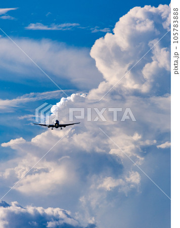 発達した積乱雲に囲まれながら進入する飛行機 105783888