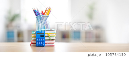 Stationery and notebooks standing on the table indoors. Stationery and notebooks standing on the table indoors. 105784150
