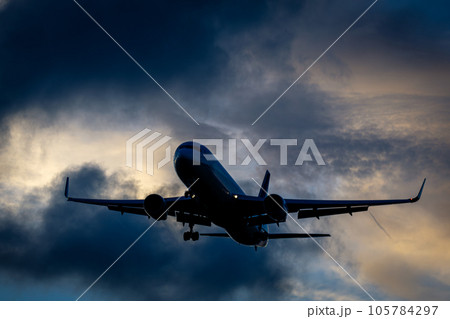 夕景を背景に最終進入を行う飛行機 105784297