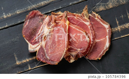 photo of dried sliced lamb meat on black wooden surface top view photo of dried sliced lamb meat on black wooden surface top view 105784396