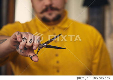 Stylish barber man with hairdressing tools in his hands prepare for work Stylish barber man with hairdressing tools in his hands prepare for work 105785775