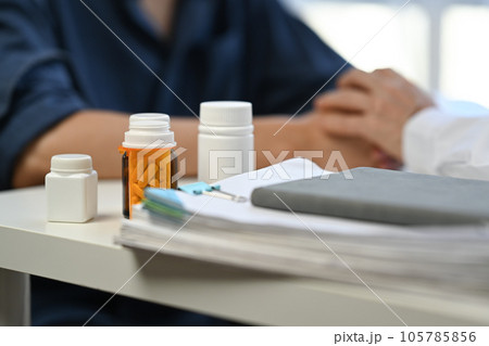 Pills bottles and medical records on table in clinic. Medical insurance, health care concept 105785856