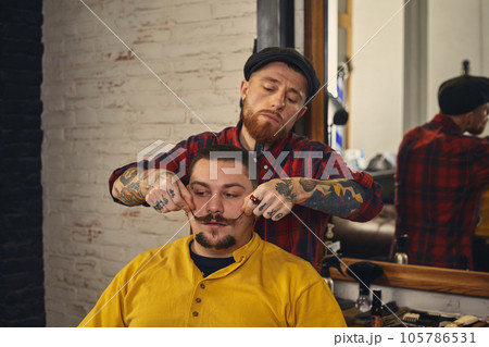 Client during beard shaving in barber shop Client during beard shaving in barber shop 105786531