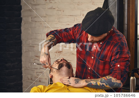 Client during beard shaving in barber shop Client during beard shaving in barber shop 105786646