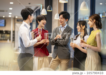 レセプション・パーティー イメージ グラスを持って歓談する若い男女 レセプション・パーティー イメージ グラスを持って歓談する若い男女 105790410