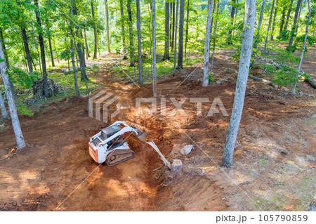 It is common practice to use tractor to move earth when preparing an area for construction 105790859
