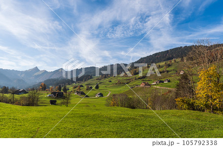 Mountain landscape in Switzerland with farmhouses, green meadows and pastures Mountain landscape in Switzerland with farmhouses, green meadows and pastures 105792338