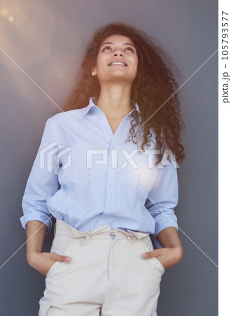 Smiling attractive young business woman in blue shirt posing on gray background Smiling attractive young business woman in blue shirt posing on gray background 105793577