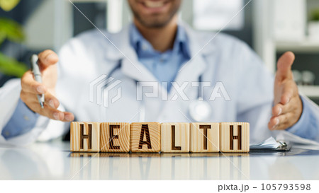 the doctor folded the word healthy from wooden cubes on the table in the hospital the doctor folded the word healthy from wooden cubes on the table in the hospital 105793598