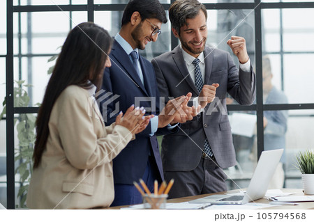 businessmen clapping their hands while standing in the office 105794568
