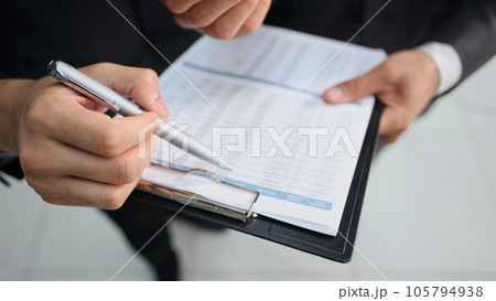 Close-up of business people discussing something while looking at financial report 105794938