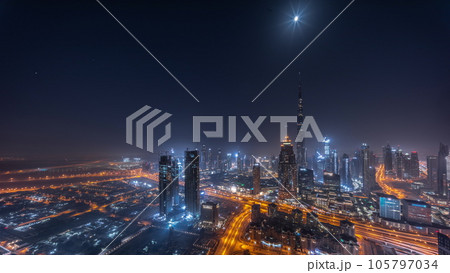Aerial view of tallest towers in Dubai Downtown skyline and highway night timelapse. Aerial view of tallest towers in Dubai Downtown skyline and highway night timelapse. 105797034
