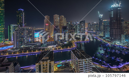 Panorama showing Dubai Marina skyscrapers and JBR district with luxury buildings and resorts aerial night timelapse Panorama showing Dubai Marina skyscrapers and JBR district with luxury buildings and resorts aerial night timelapse 105797146