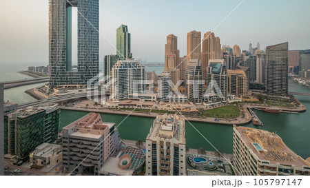 Panorama showing Dubai Marina with several boat and yachts parked in harbor and skyscrapers around canal aerial timelapse. 105797147