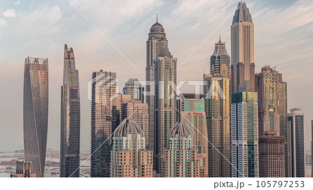 Skyscrapers of Dubai Marina near intersection on Sheikh Zayed Road with highest residential buildings night to day timelapse 105797253