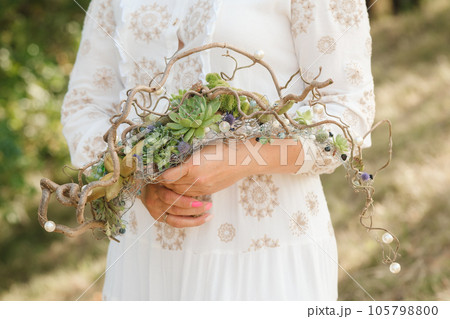 The bride holds an unusual braided wedding bouquet in her hands 105798800