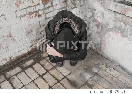 A teenager sits alone after using drugs and alcohol in an abandoned house. Addiction concept A teenager sits alone after using drugs and alcohol in an abandoned house. Addiction concept 105799269