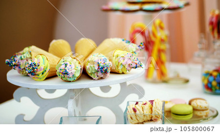 Candy bar on children's birthday. close-up, multi-colored lollipops, sweets, biscuit, cupcakes, sweet decoration for children's parties and children's anniversaries. 105800067